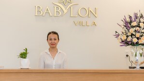 A reception desk with a sign reading "BABYLON VILLA".