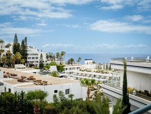 A coastal residential area with white buildings, some with balconies, and a clear view of the sea.