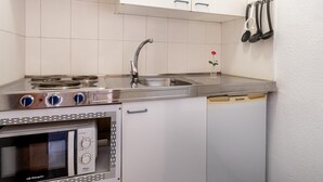 A compact kitchen with a stove, sink, and oven. - Lovely Studio Club Atlantis (Costa Adeje)
