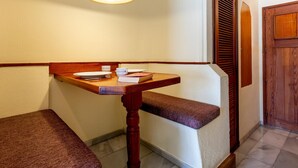 A corner room with a wooden bench, a table with a white plate, a cup, and a book. - Lovely Studio Club Atlantis (Costa Adeje)