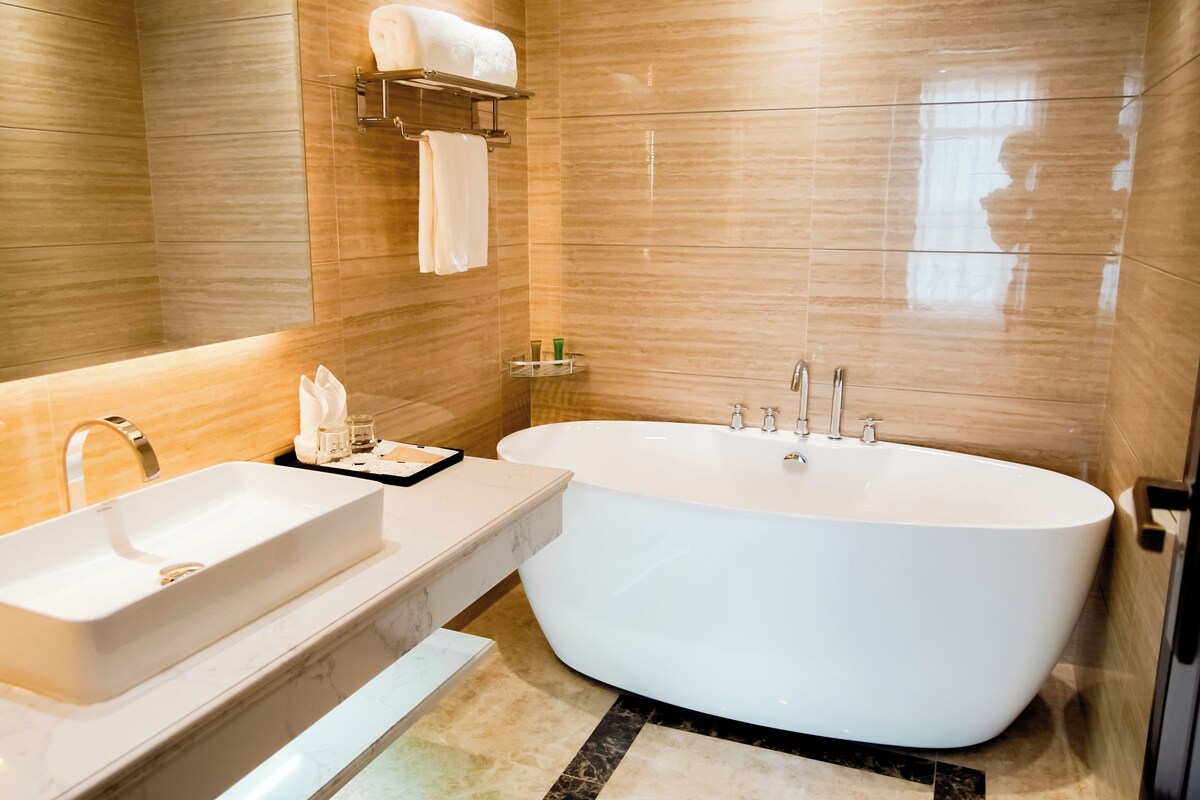 Une salle de bain moderne avec une baignoire sur pieds, un meuble-lavabo et un porte-serviettes.