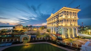 Un grand hôtel, bien éclairé, avec de nombreux étages et une entrée imposante.