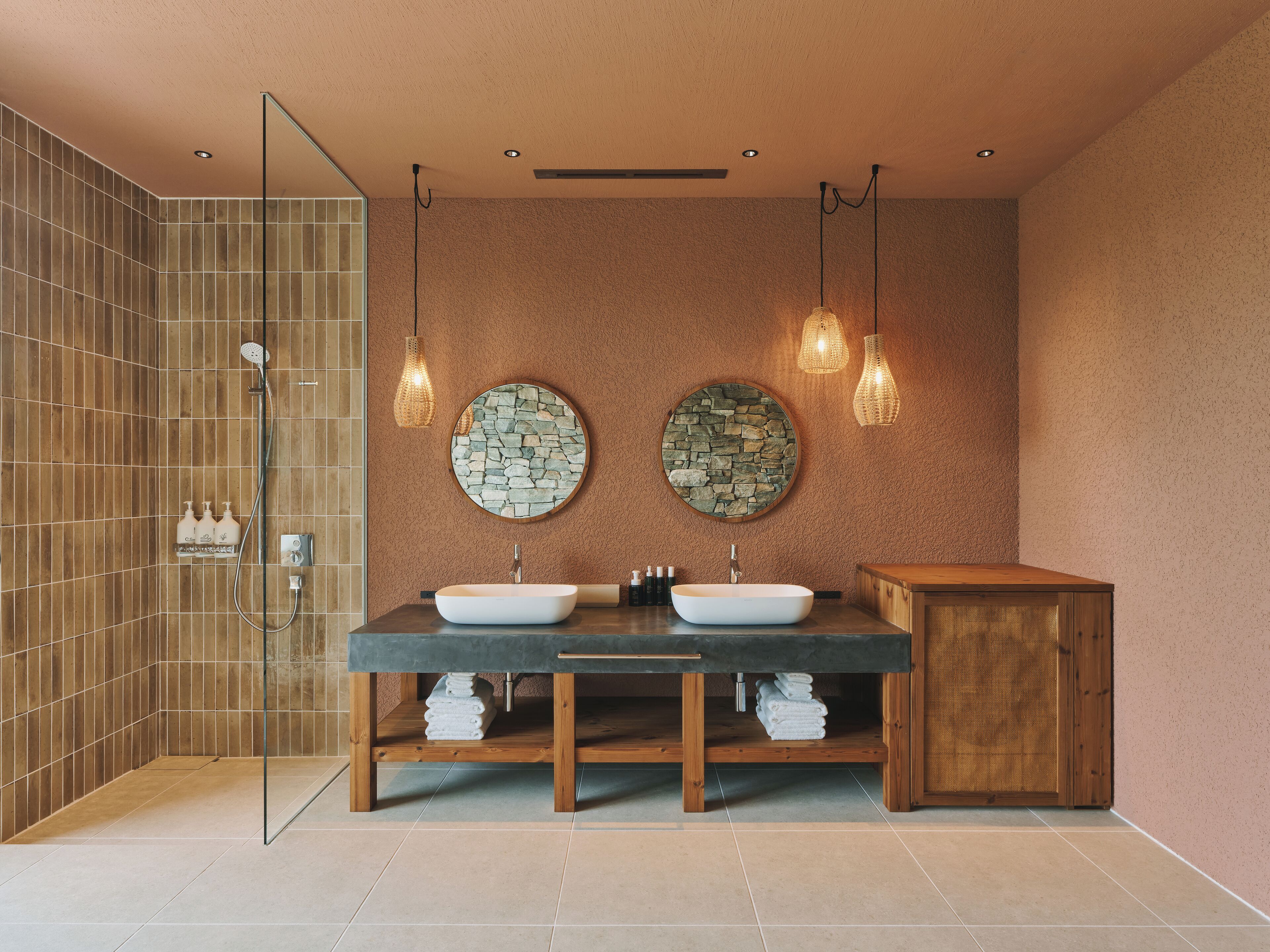 Une salle de bain moderne avec deux lavabos, une douche et un meuble-lavabo en bois.