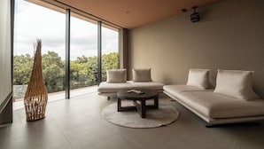A modern living room with a large window, a sofa set, a coffee table, and a decorative vase. - Villa El Cielo Ishigaki (Ishigaki)