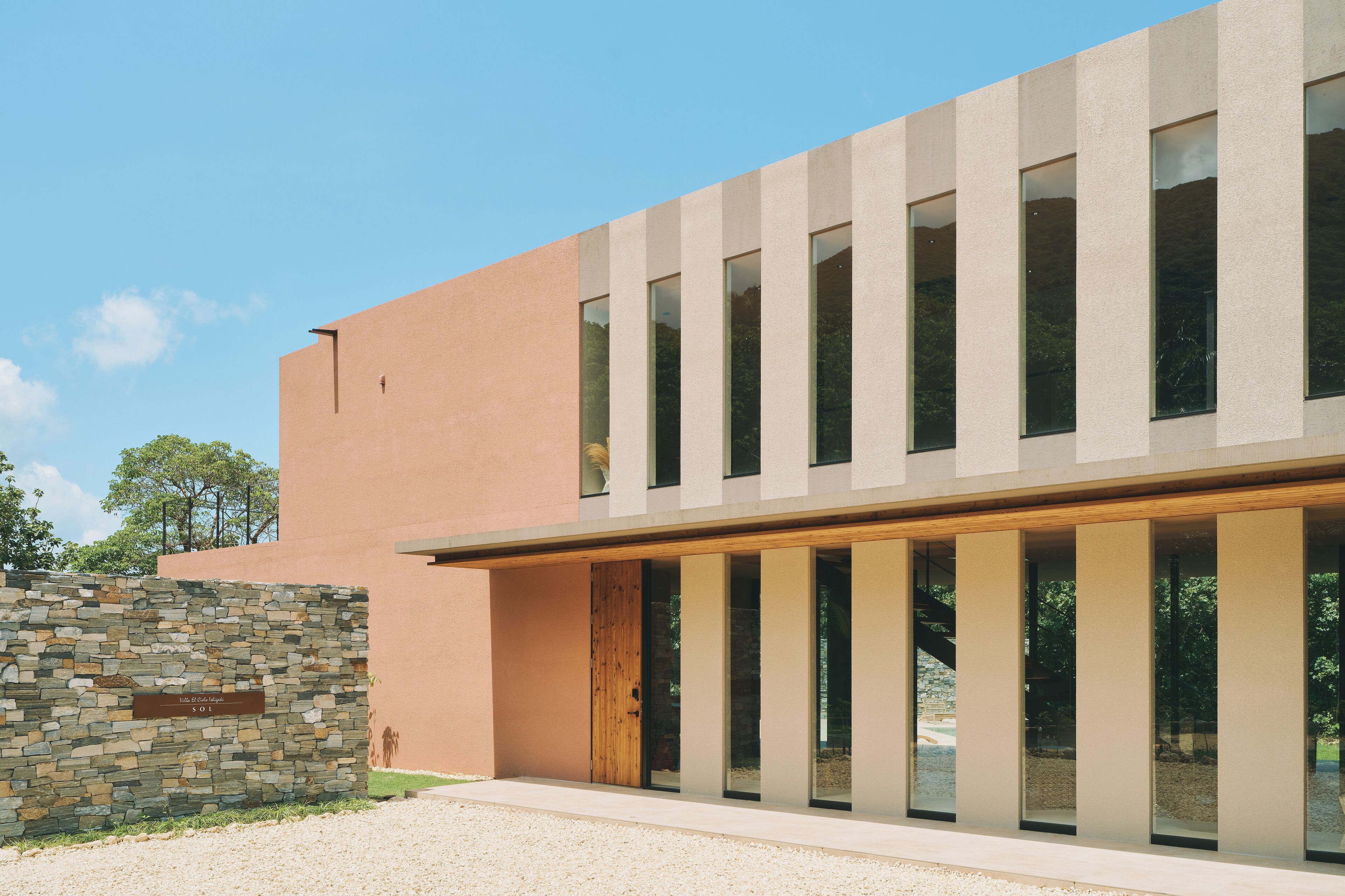 Un bâtiment moderne avec un mur en pierre et de grandes fenêtres.