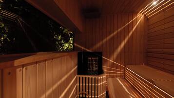 Una sauna in legno con panche e un piccolo ambiente chiuso con uno scaldabagno.