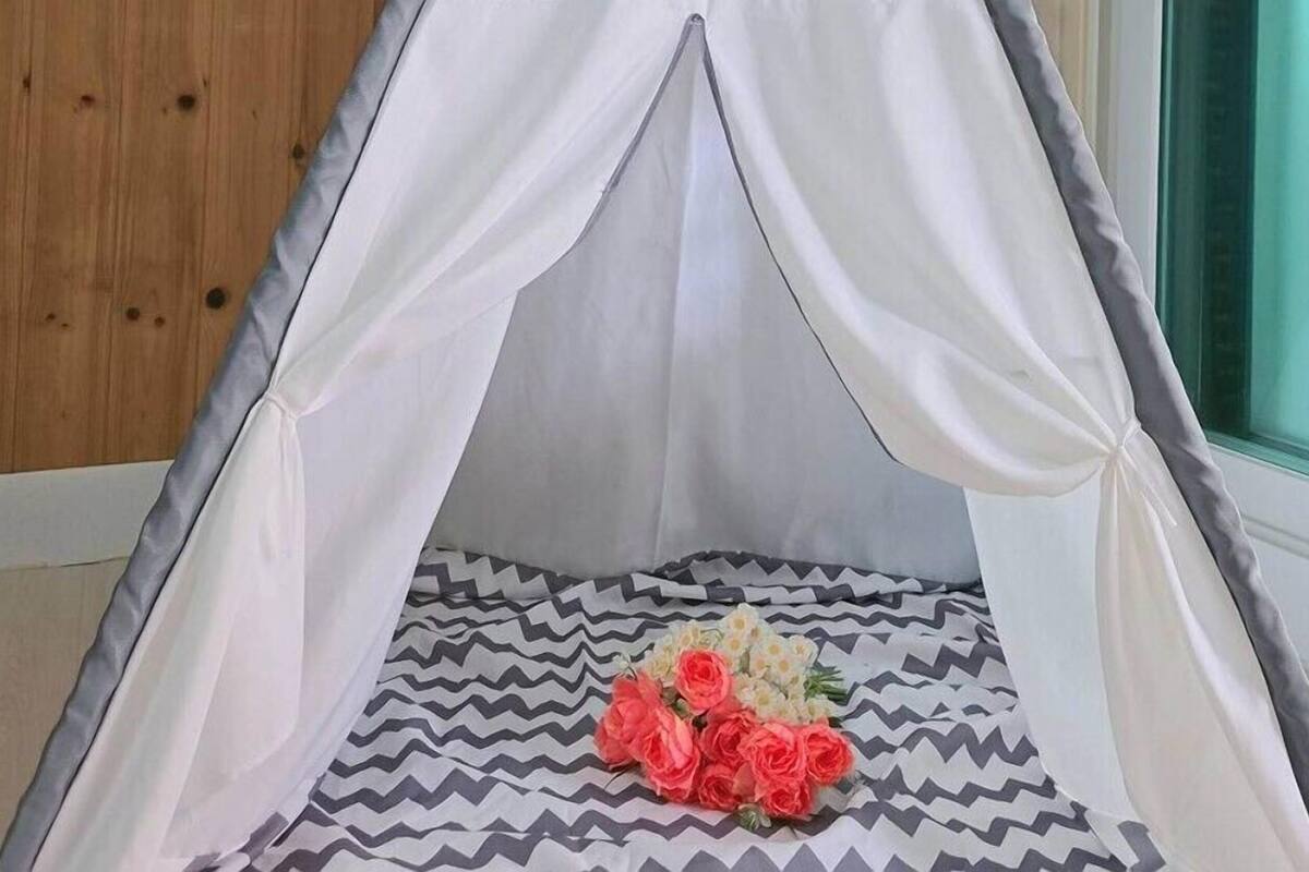A tent-like structure with a patterned floor and a bouquet of flowers.