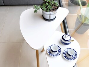 Enjoy a serene space with a clean table, potted plant, and elegant tableware.