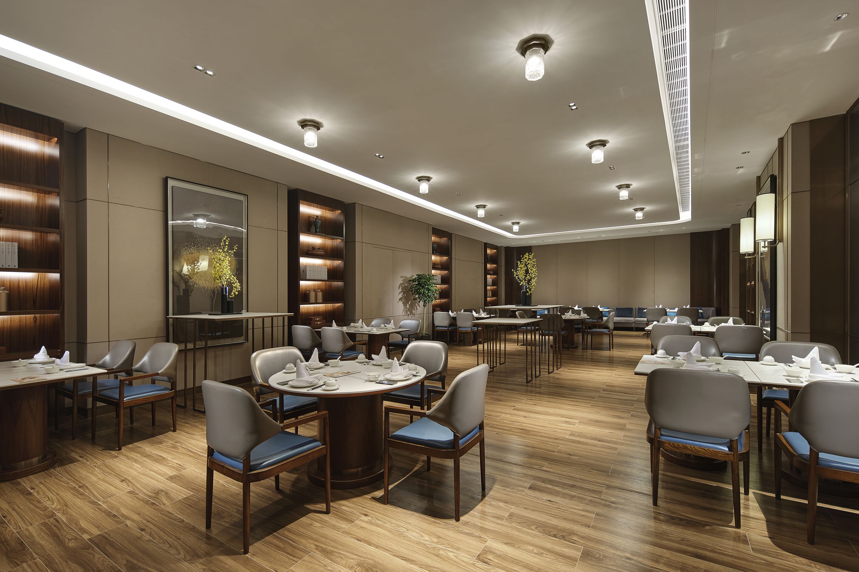 Un vaste espace dédié à la salle à manger, avec de nombreuses tables et chaises, un éclairage encastré et un design moderne.