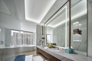 A modern bathroom with a large mirror, marble walls, and a window with a city view. - Yuanchang Grand Harbourview Hotel (Quanzhou)