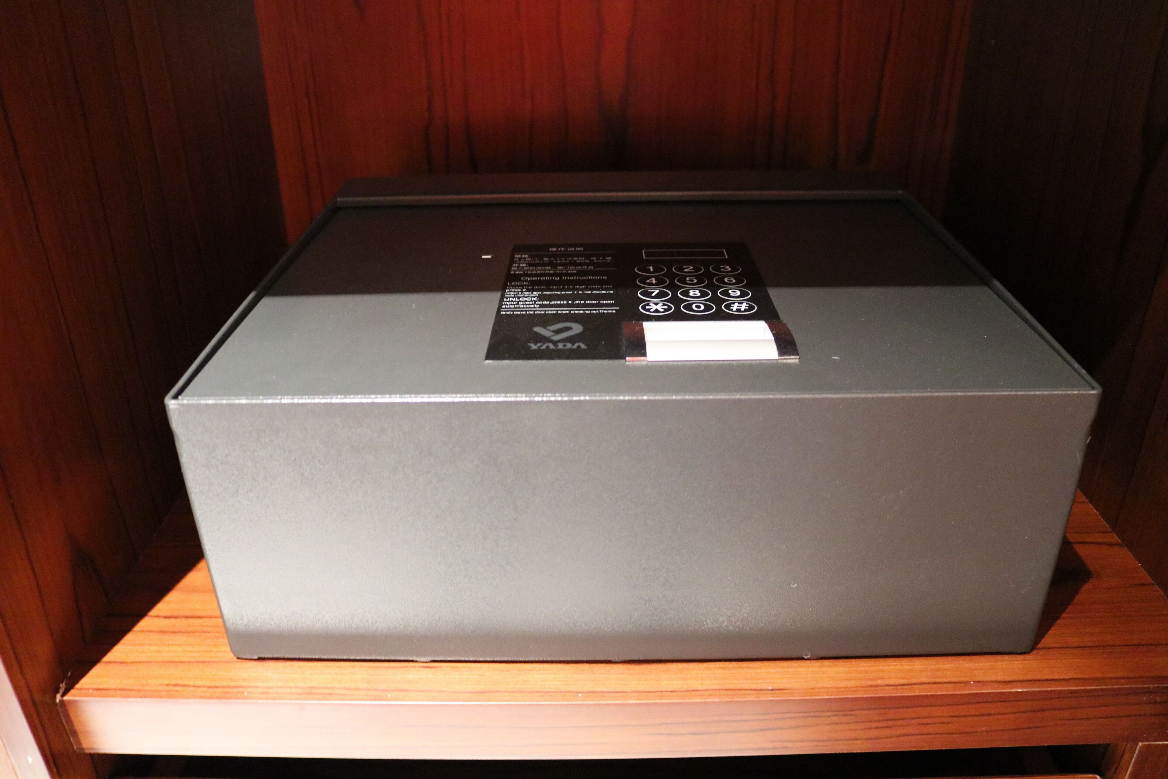 A gray box with a YADA logo on a wooden surface.