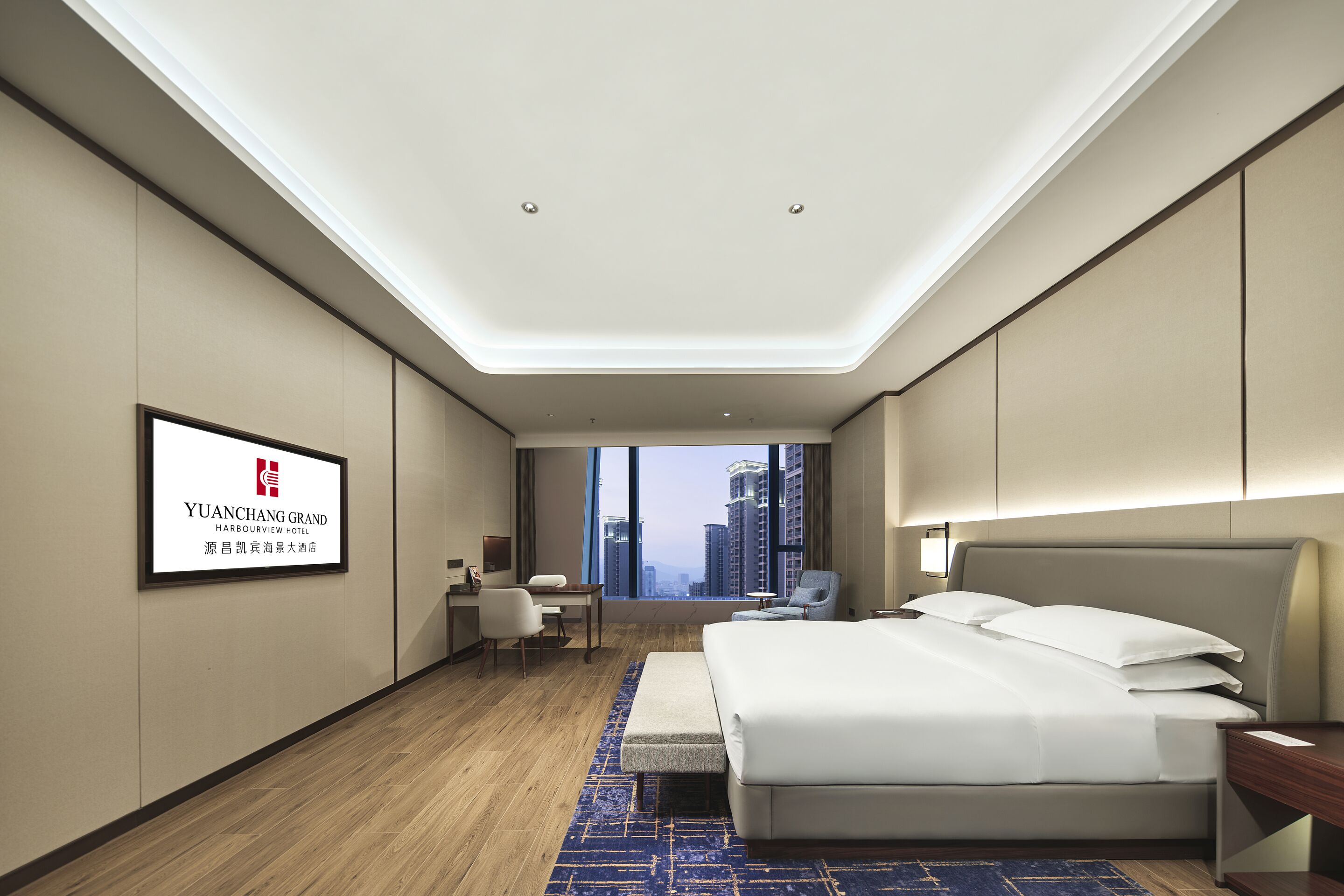 A modern hotel room with a large bed, a desk, a chair, and a view of the cityscape.