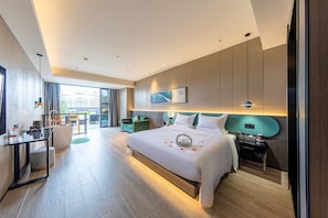 A modern hotel room with a large bed, a desk, a chair, and a view of the city. - Kardon Hotel.Stars (Guangzhou)