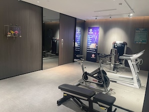A modern gym with exercise equipment, a mirrored wall, and a no-smoking sign. - Kardon Hotel.Stars (Guangzhou)