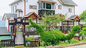 A large, two-story house with a prominent balcony and a small porch area. - Mangyang Full House (Geoje)