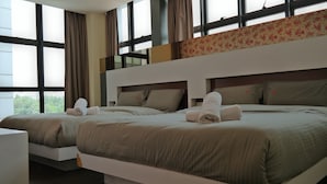 Habitación de hotel con dos camas, ventanas amplias y un balcón.