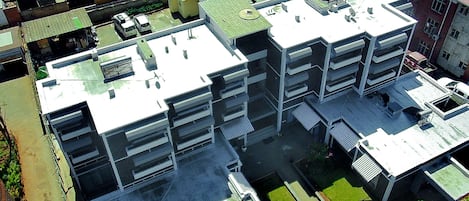 Un edificio de varios pisos con techo plano, varios balcones y un patio central.