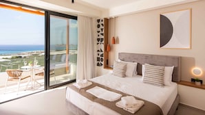 Camera d'albergo moderna con un letto grande, un balcone vista mare e un arredamento minimalista.