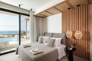 A bedroom with a large bed, a view of the ocean, and a wooden wall. - Villa Domenica Free* heated pool & Seaviews (Kissamos)