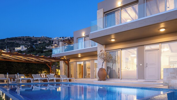 A modern hotel with a swimming pool, outdoor seating, and a view of the surrounding landscape. - Villa Elpida Sea view & heated* pool! (Kissamos)