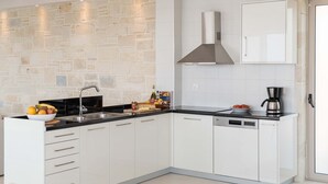A modern kitchen with white cabinets, a stone backsplash, a stainless steel range hood, and a dishwasher. - Villa Galatia I Free*heated pool, ideal for groups (Kissamos)