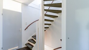 Una escalera moderna con pared blanca y peldaños alfombrados.