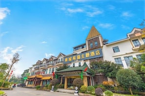 A hotel with a traditional architectural style, featuring a prominent green roof and multiple stories.