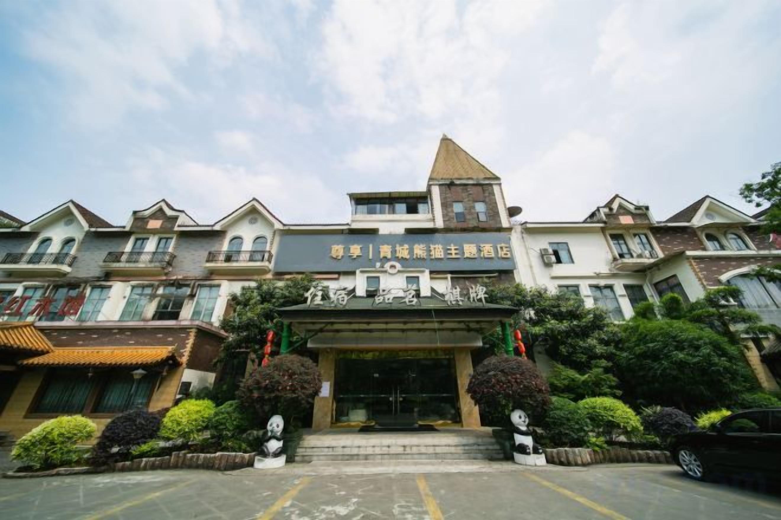 A hotel entrance with a traditional architectural style, featuring a central tower and multiple balconies.