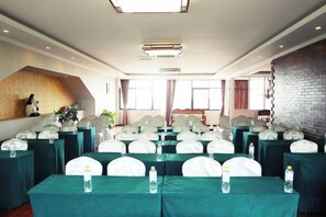 A conference room with rows of tables, chairs, and water bottles. - Qingcheng Panda Hotel (Dujiangyan)