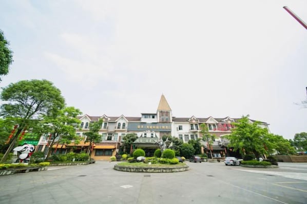 A hotel with a central courtyard, multiple floors, and a prominent tower. - Qingcheng Panda Hotel (Dujiangyan)