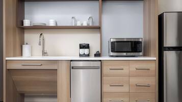 A modern kitchen with a dishwasher, microwave, and refrigerator.