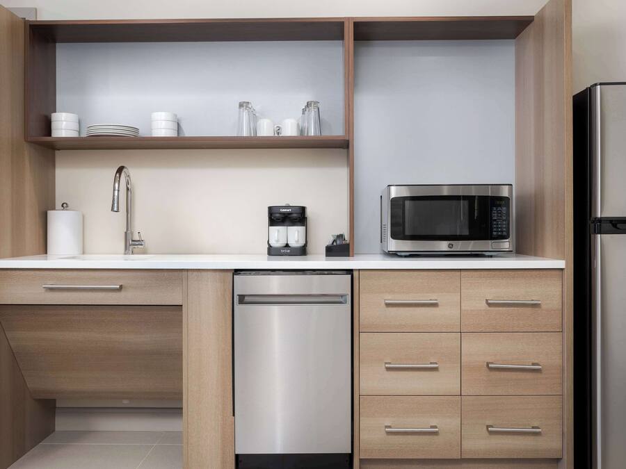 A modern kitchen with a dishwasher, microwave, and refrigerator.