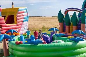 Kids can play and climb in a fun outdoor play area with a castle, rocket ship, and dinosaur-themed zone.