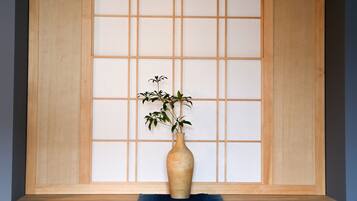 A wooden shelf with a vase containing a plant.
