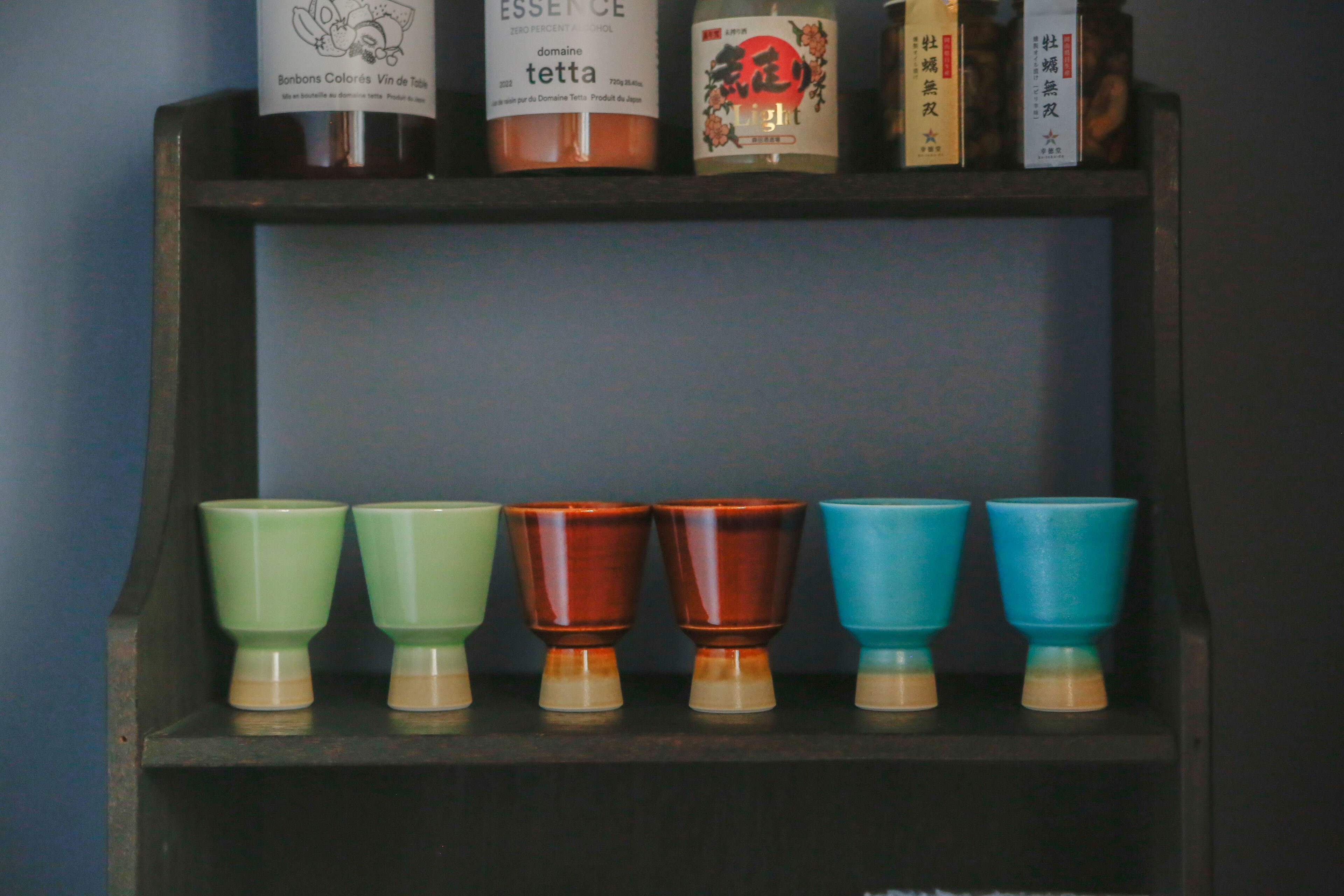 Una estantería con varios objetos, incluyendo botellas y vasos.