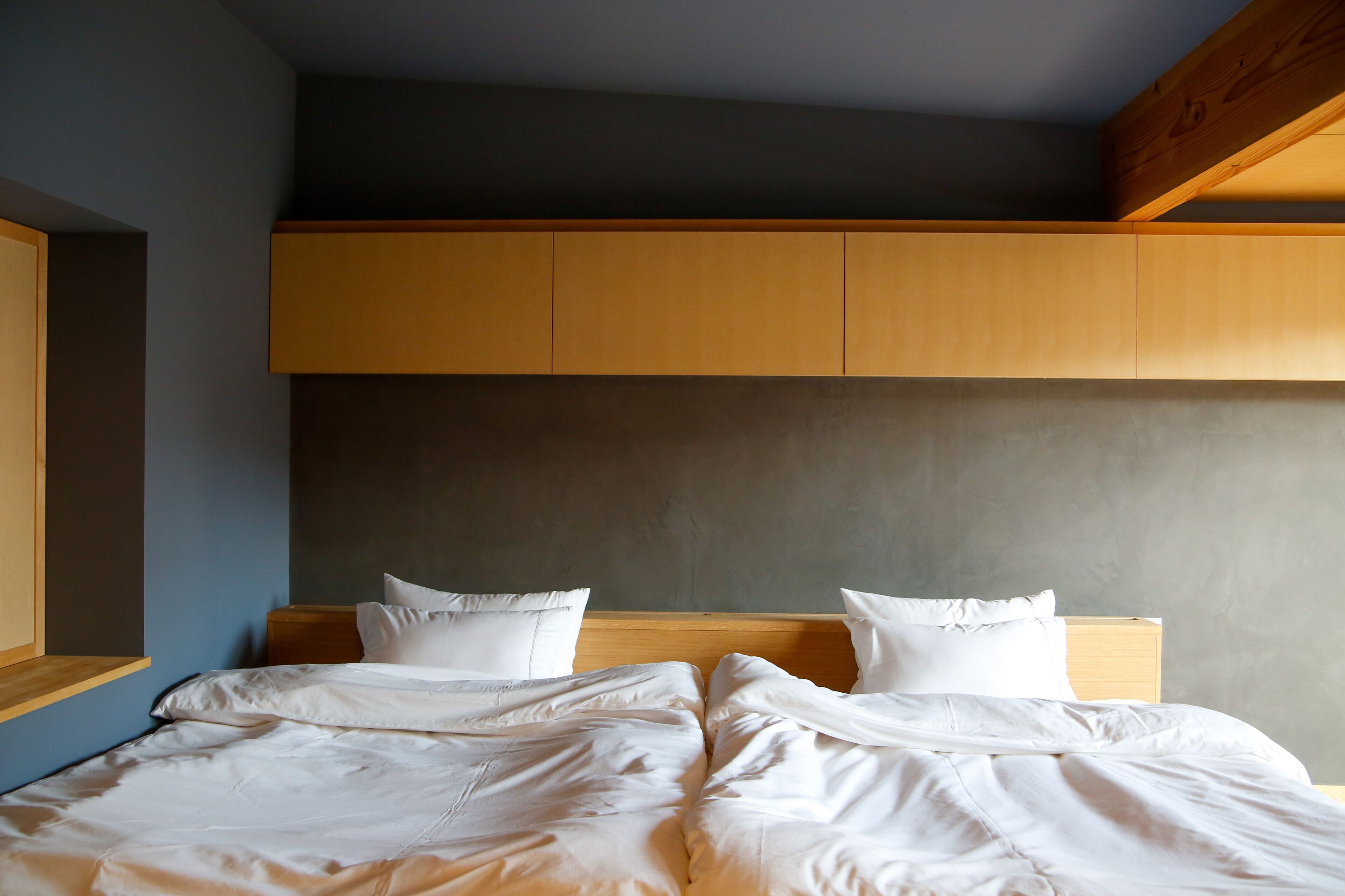 Ein Schlafzimmer mit einem großen Bett, einem Holz-Kopfteil und eingebauten Stauraumschränken.