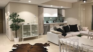 Un salon moderne avec un canapé blanc, une vitrine, une table à manger avec des chaises et un tapis en cuir.