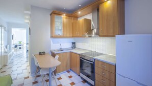 Une cuisine moderne avec des meubles en bois, un four encastré et un réfrigérateur.