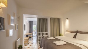 Une chambre d’hôtel équipée d’un lit, d’un bureau, de chaises et offrant une vue sur l’extérieur.