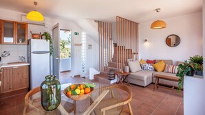 Un salon moderne avec un canapé, une table basse en verre et un saladier rempli de fruits.