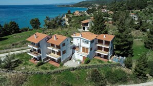 Un edificio residenziale a più piani con balconi, situato vicino alla costa e con vista sul mare.