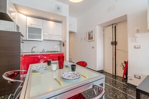 Una cucina moderna con pensili rossi, un tavolo da pranzo in vetro e una sedia rossa.