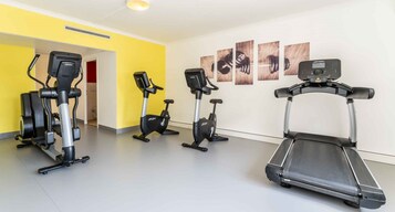 Una palestra con tapis roulant, ellittiche e una cyclette.