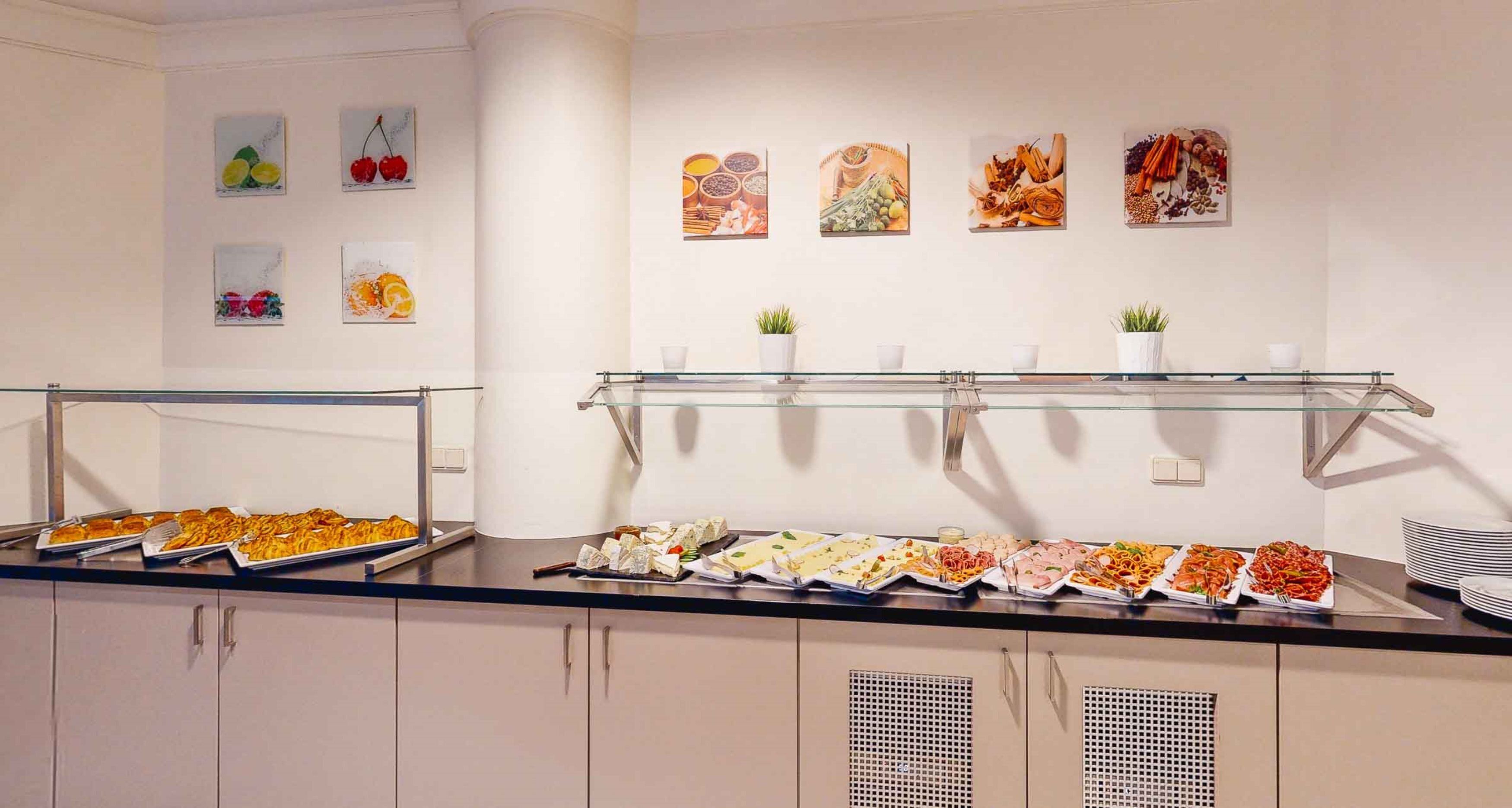 A buffet area with various food options and wall art.