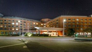 A multi-story hotel with a central atrium and a parking lot. - PLAZA Premium Wien (Vienna)