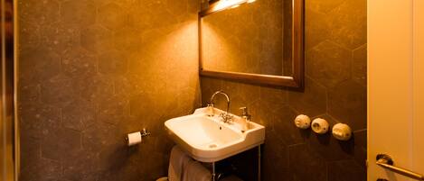 A bathroom with a white sink, a mirror, and a toilet.
