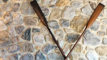Un mur de pierres sur lequel sont croisées deux battes de baseball en bois.