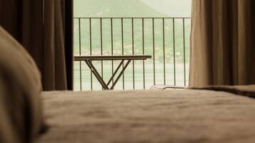 Un lit donnant sur un balcon avec vue sur un paysage montagneux.