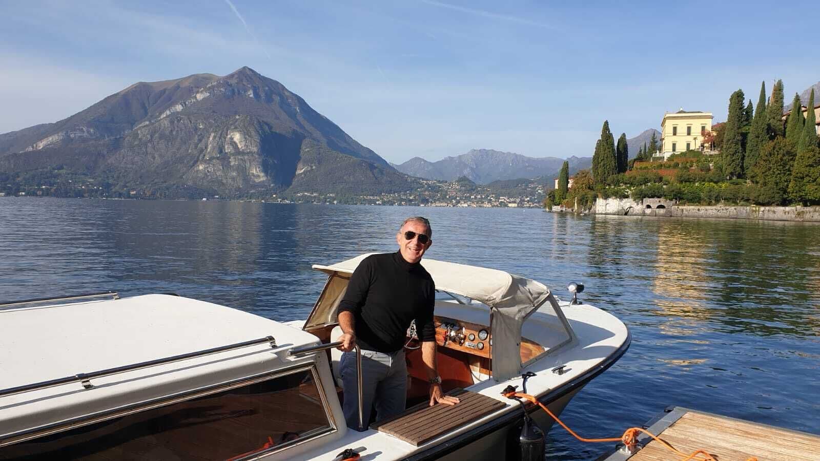 A boat docked near a body of water with a mountain in the background.