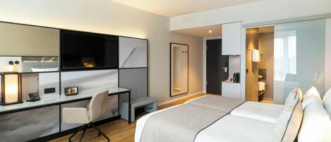 Quarto de hotel moderno com cama, escrivaninha, cadeira e closet espaçoso.